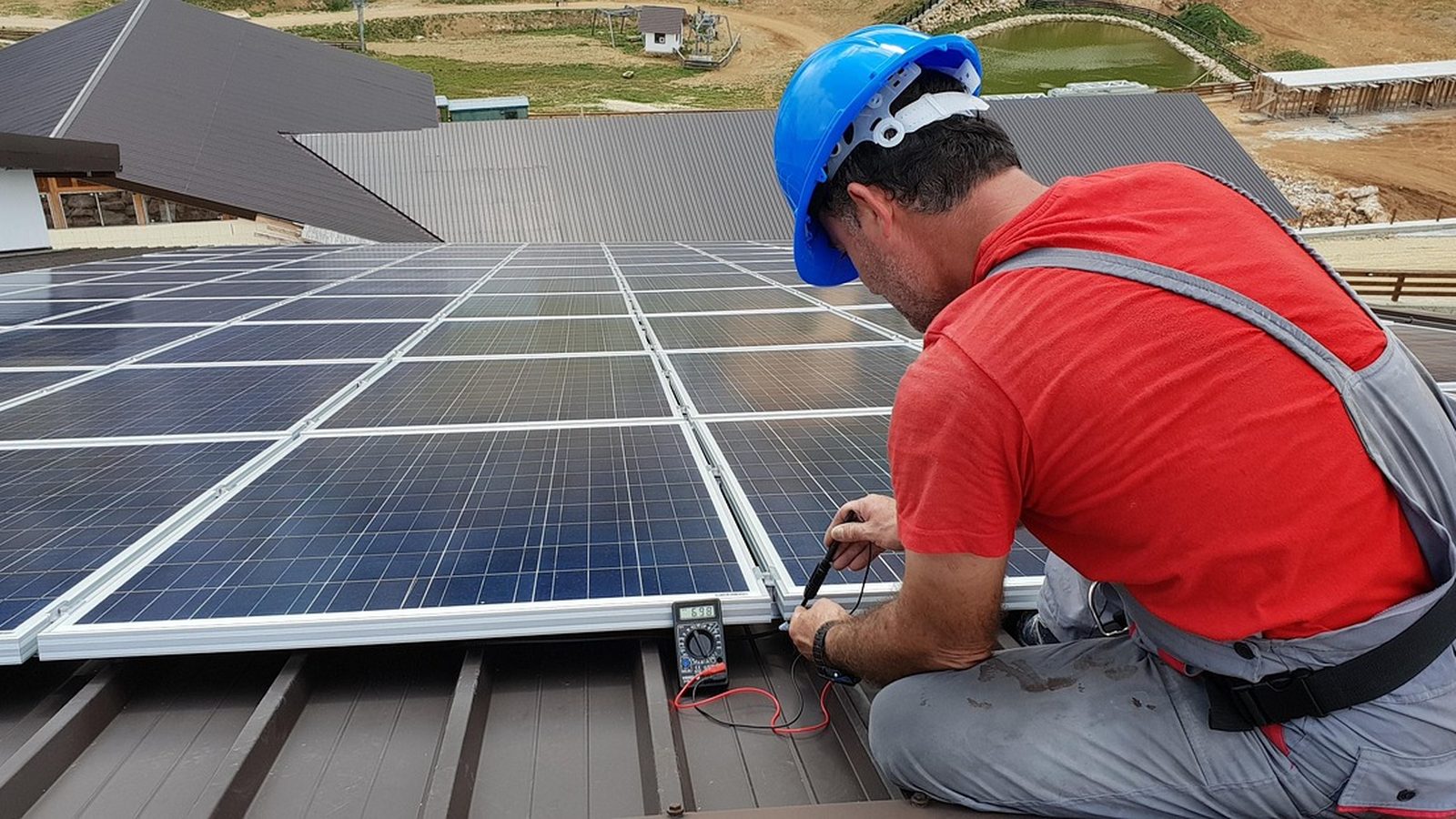 Technician working on a rooftop solar panel installation