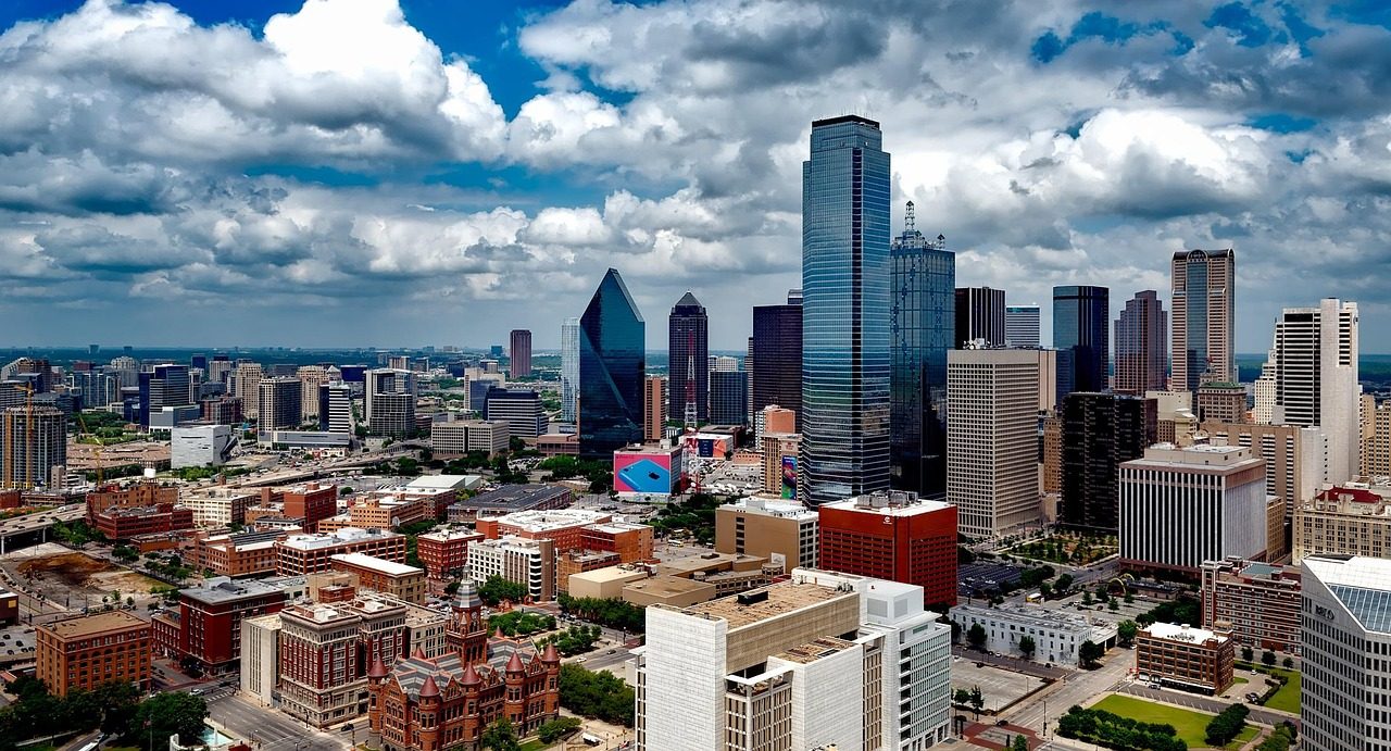 Dallas skyline with downtown buildings under a cloudy blue sky