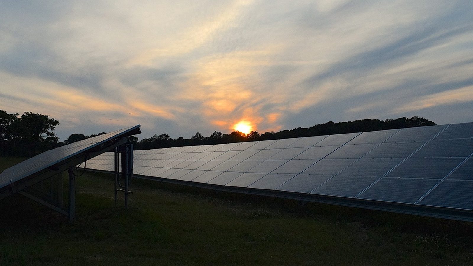 Rooftop solar panels against a sunset sky
