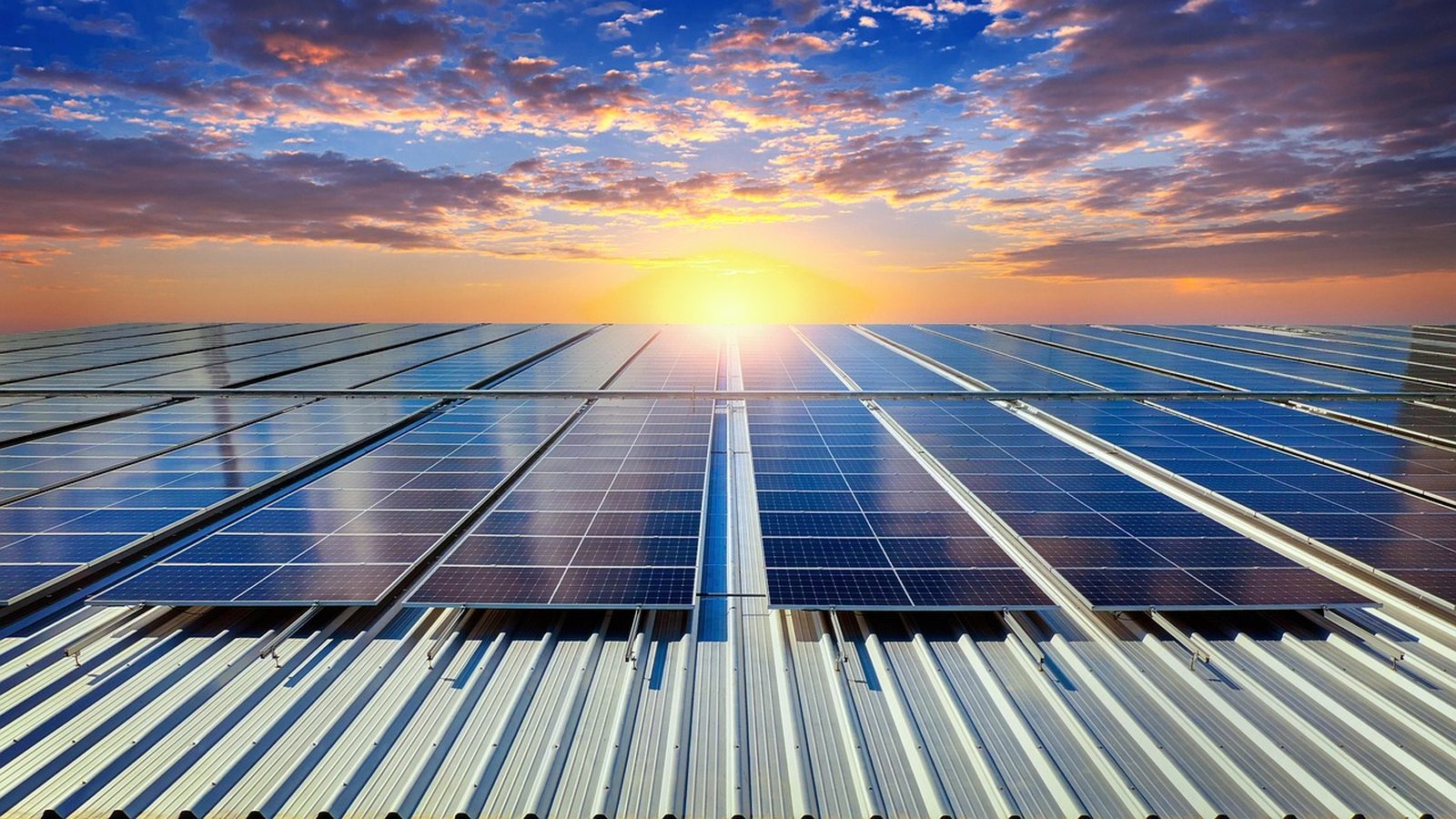 Sun setting over rows of rooftop solar panels