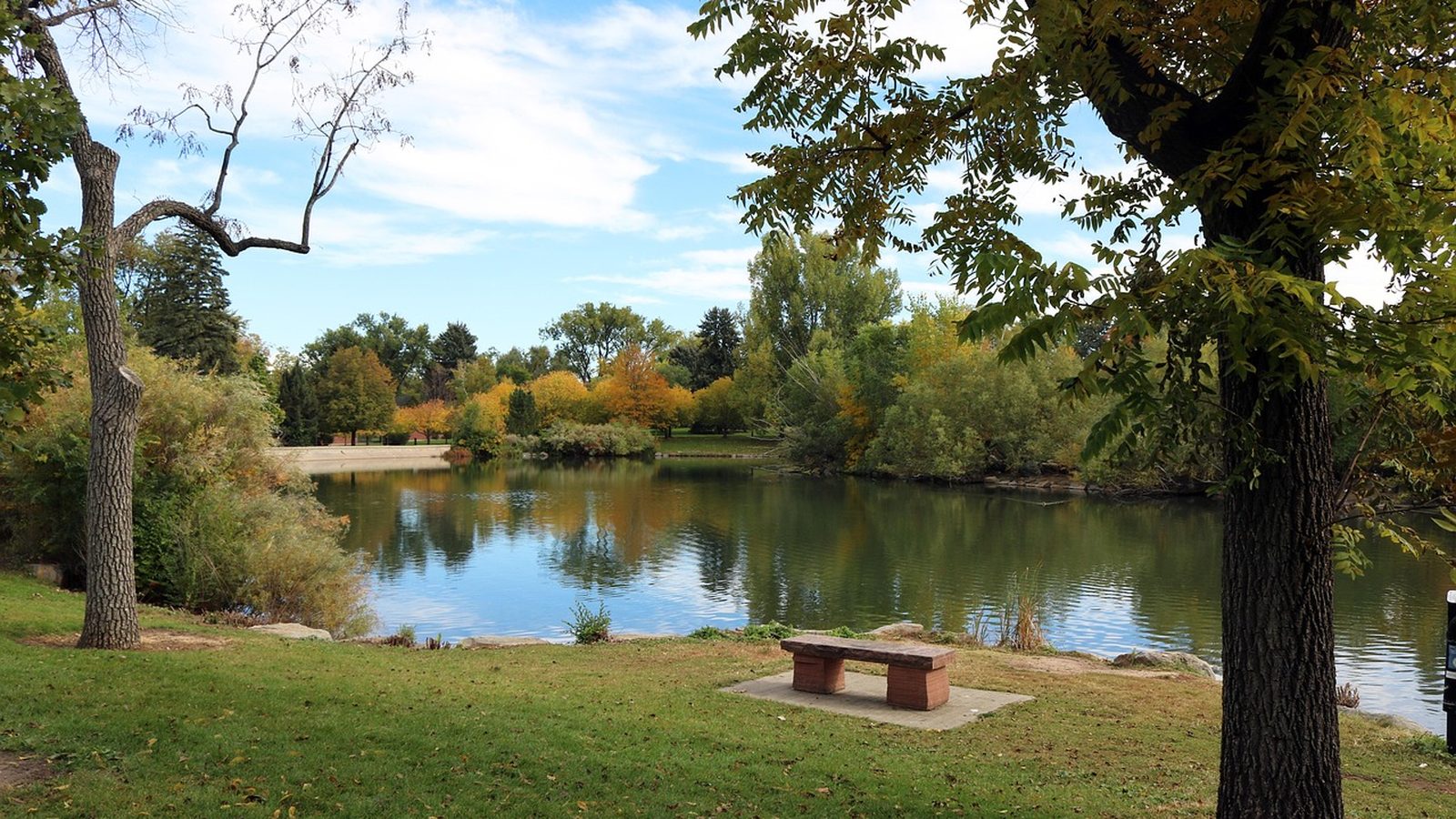 Autumn trees around the lake at Glenmere Park in Greeley, Colorado