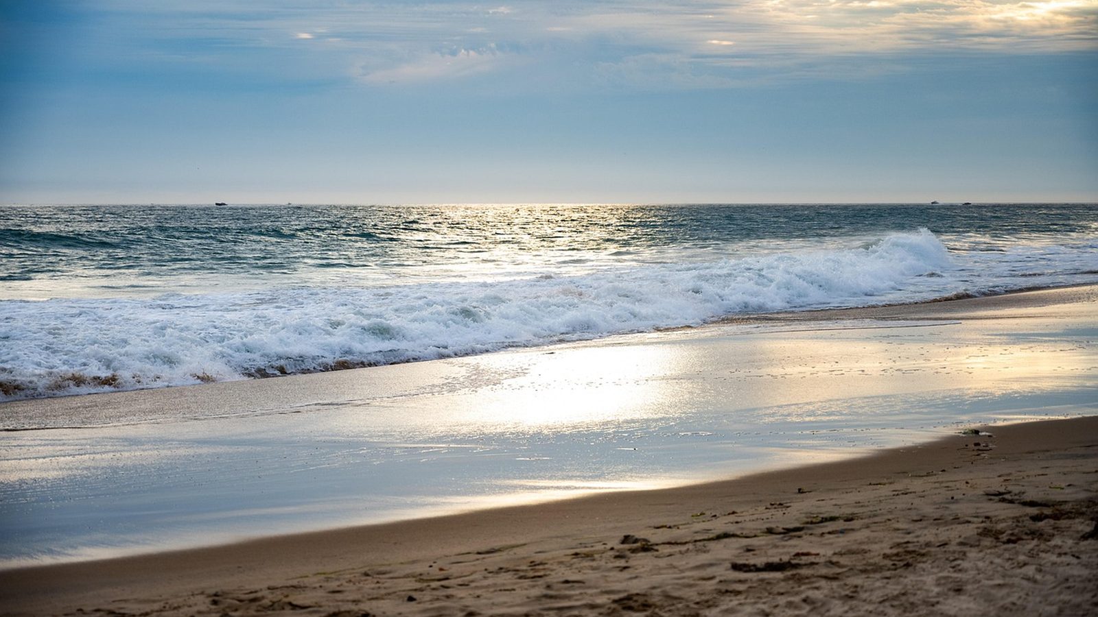 Waves rolling toward the Newport Beach shoreline at sunset