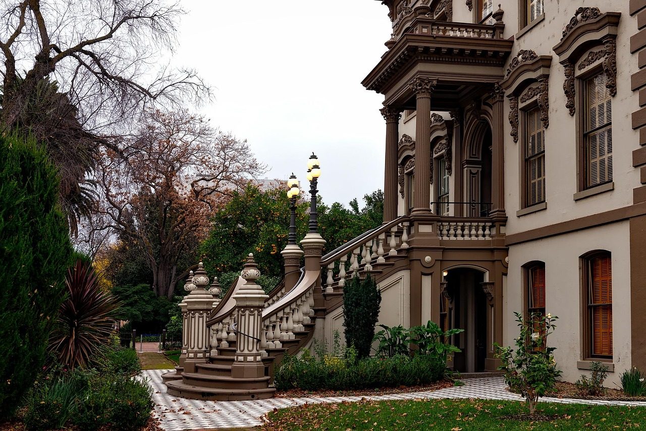 Leland Stanford Mansion in Sacramento with a stairway and shrubs at sunset