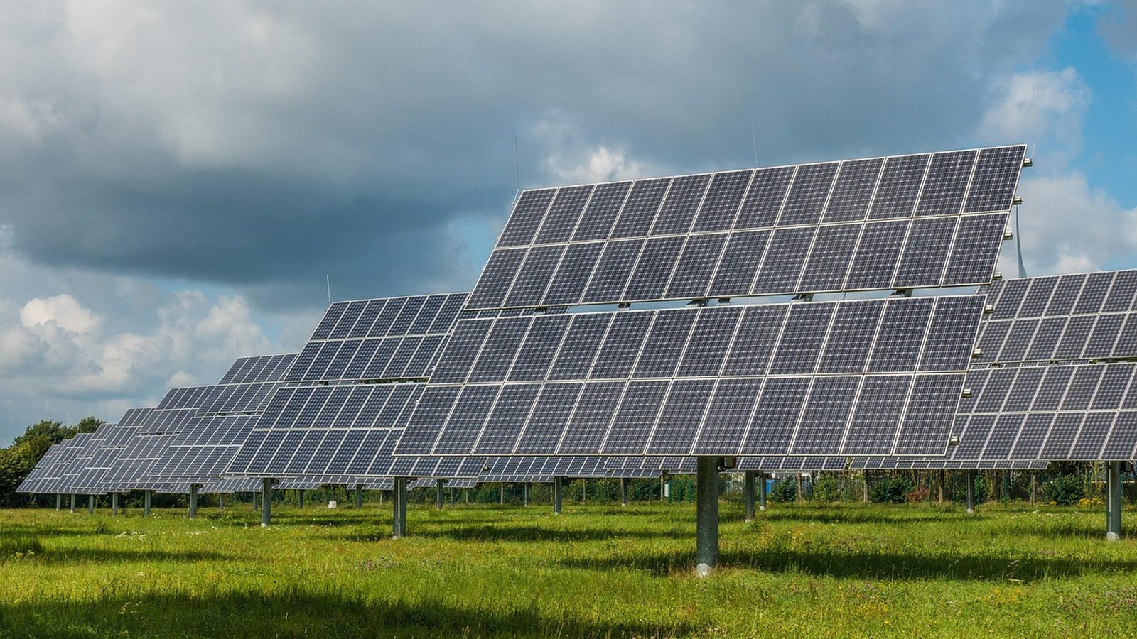Photovoltaic array under a partly cloudy desert sky