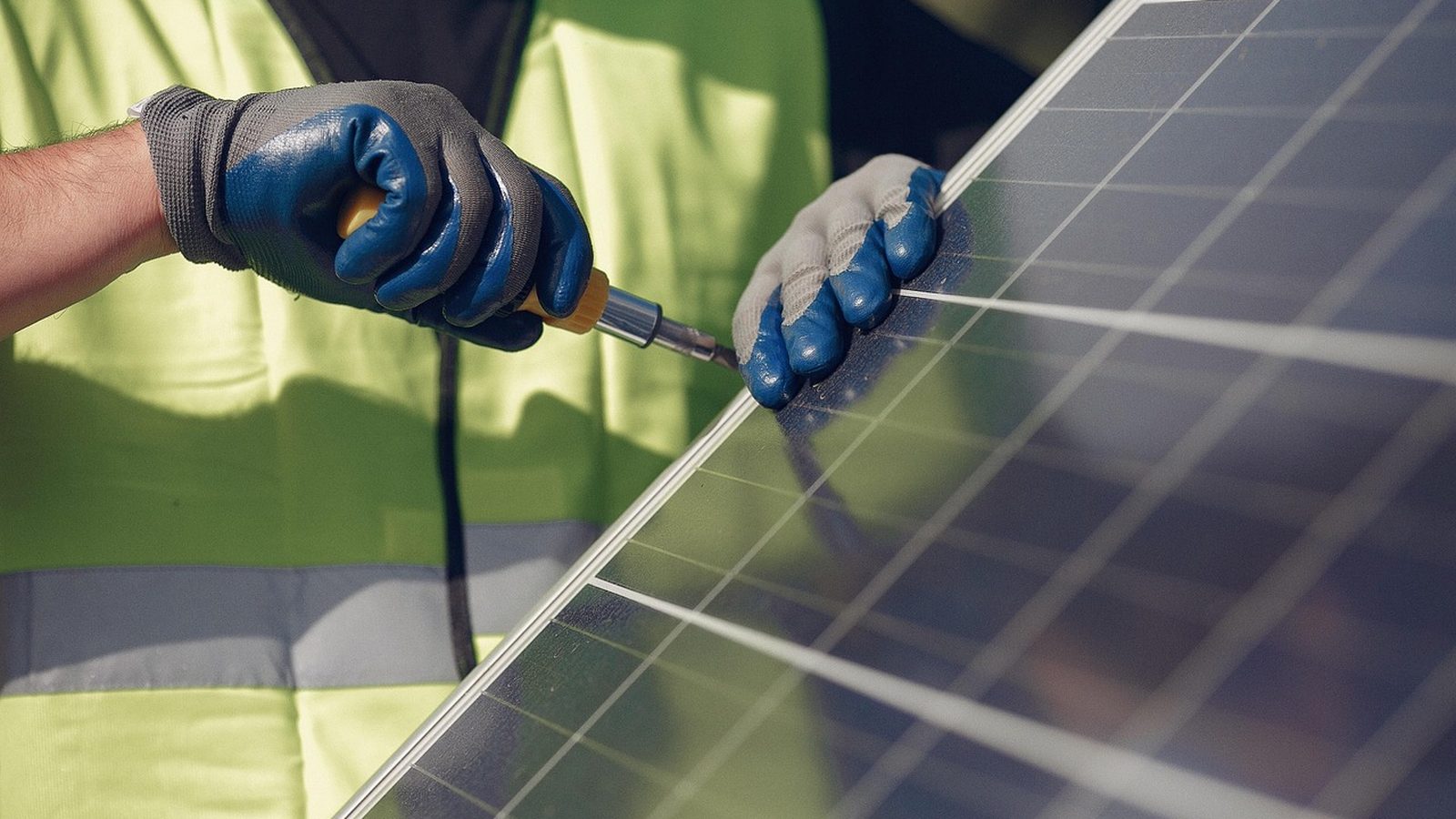 Solar installer fitting a panel on a rooftop