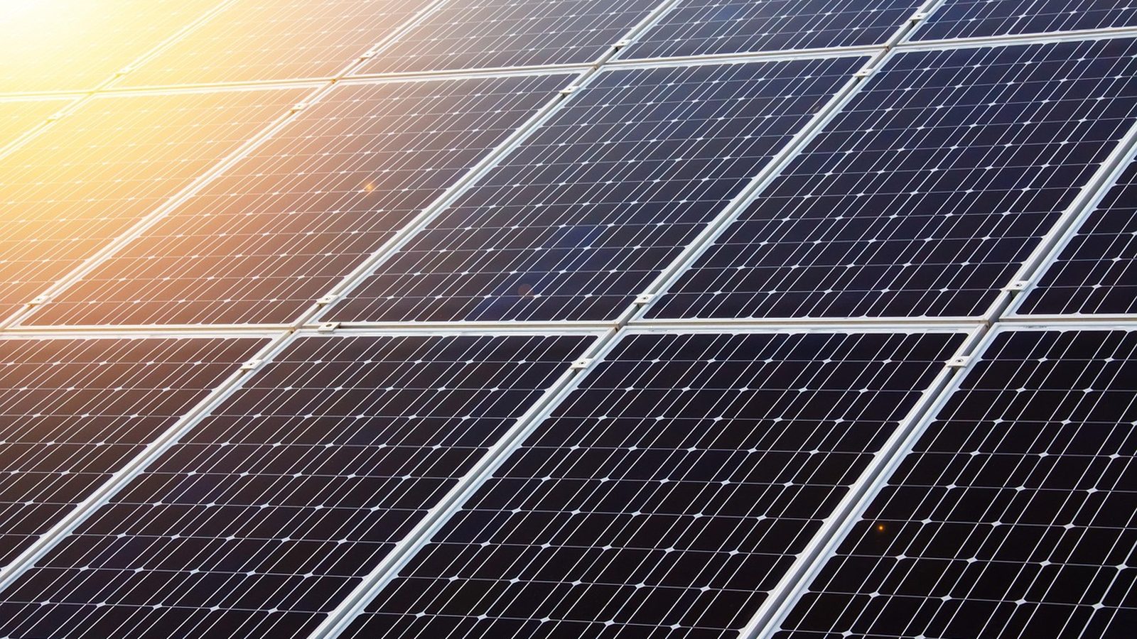 Blue photovoltaic panels angled toward a clear sky