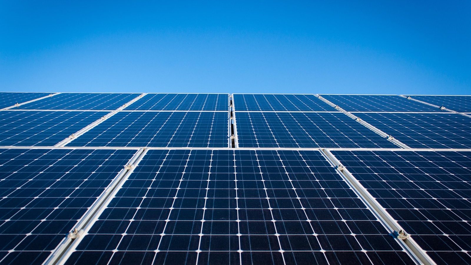Solar panel array under a deep blue sky